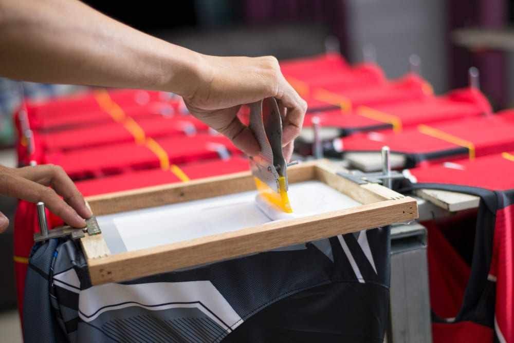 Hands screen printing red ink