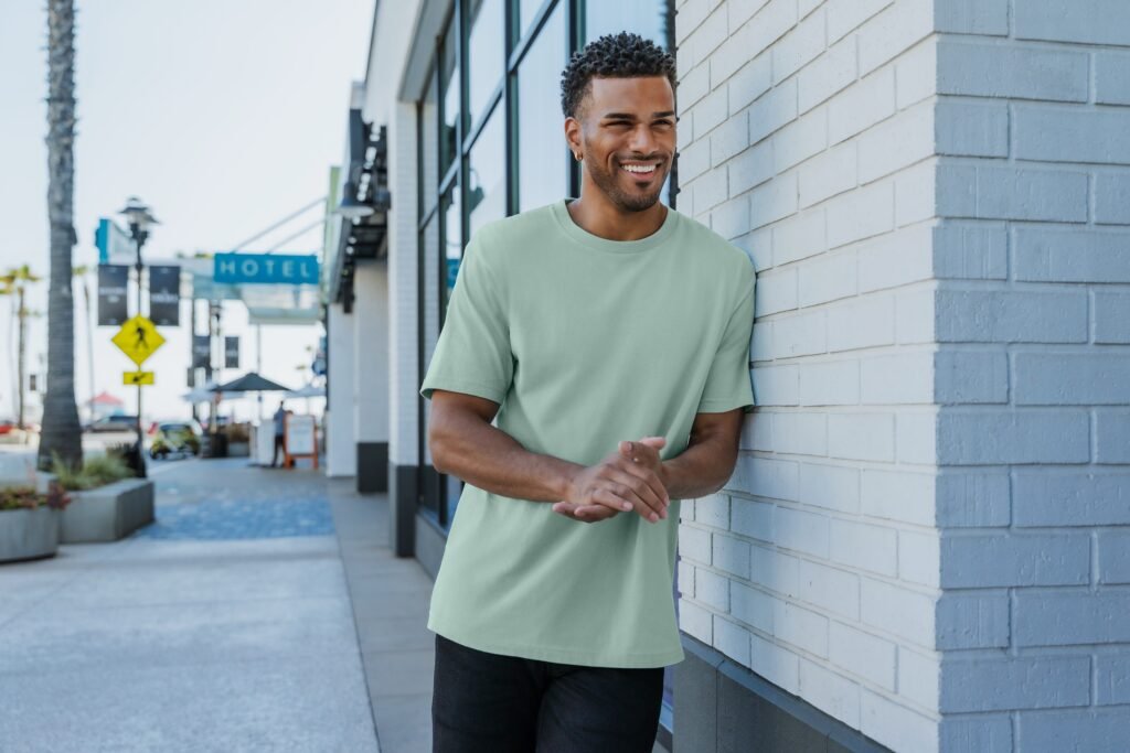 Man in sage green t-shirt by wall